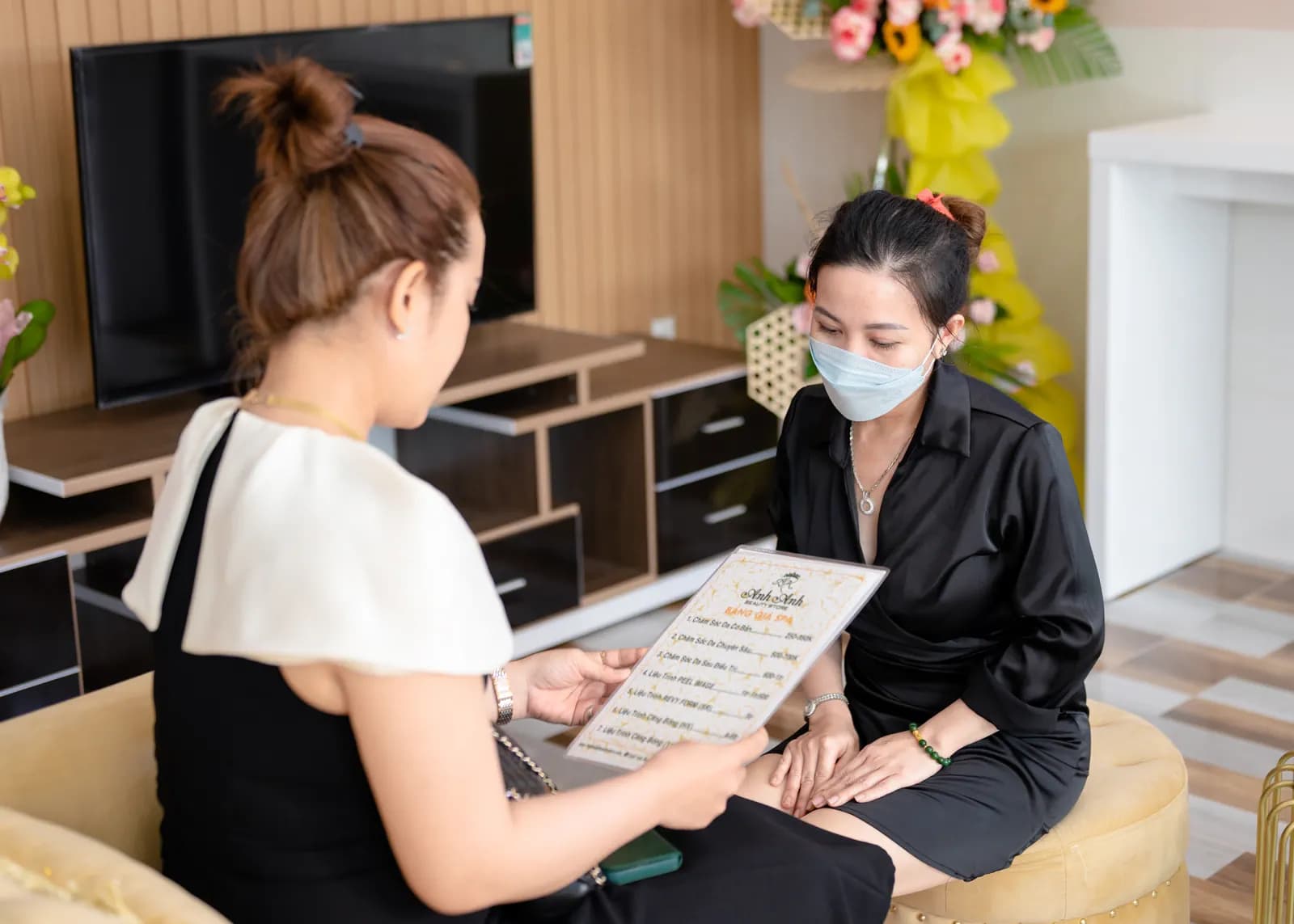 Hai người cùng nhìn xuống một tờ giấy trên ghế đôn