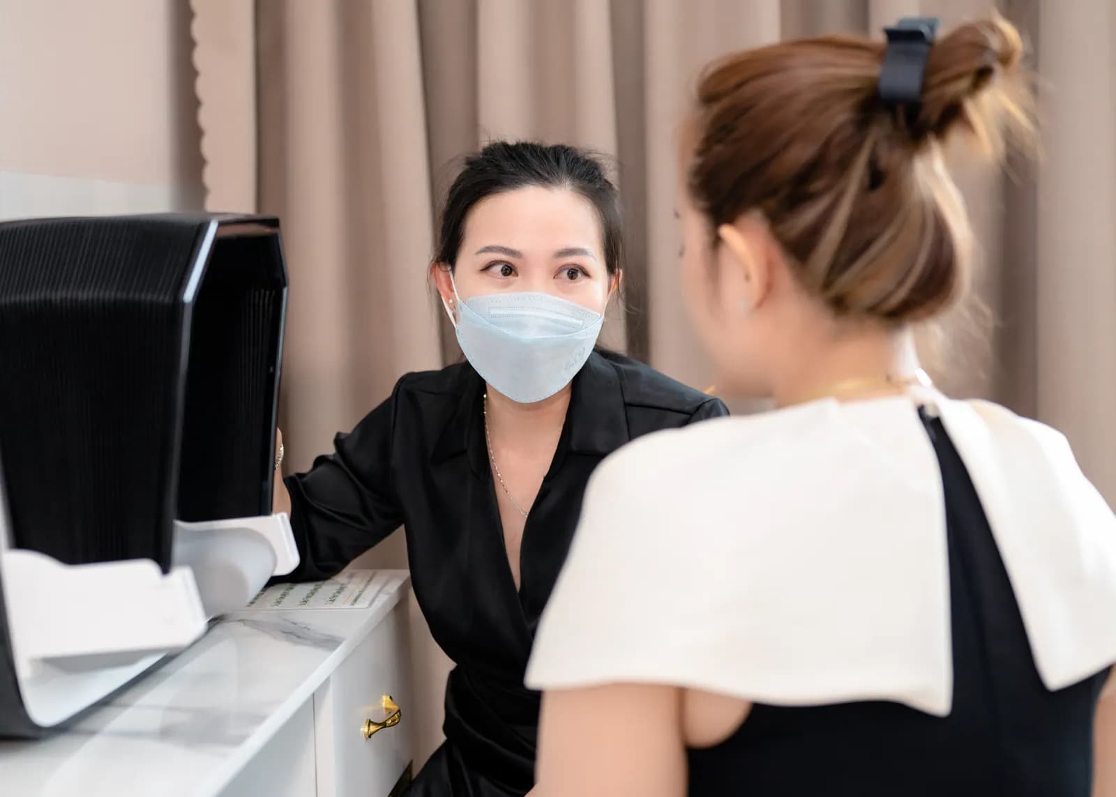Hai người trò chuyện cạnh thiết bị đặt trên bàn