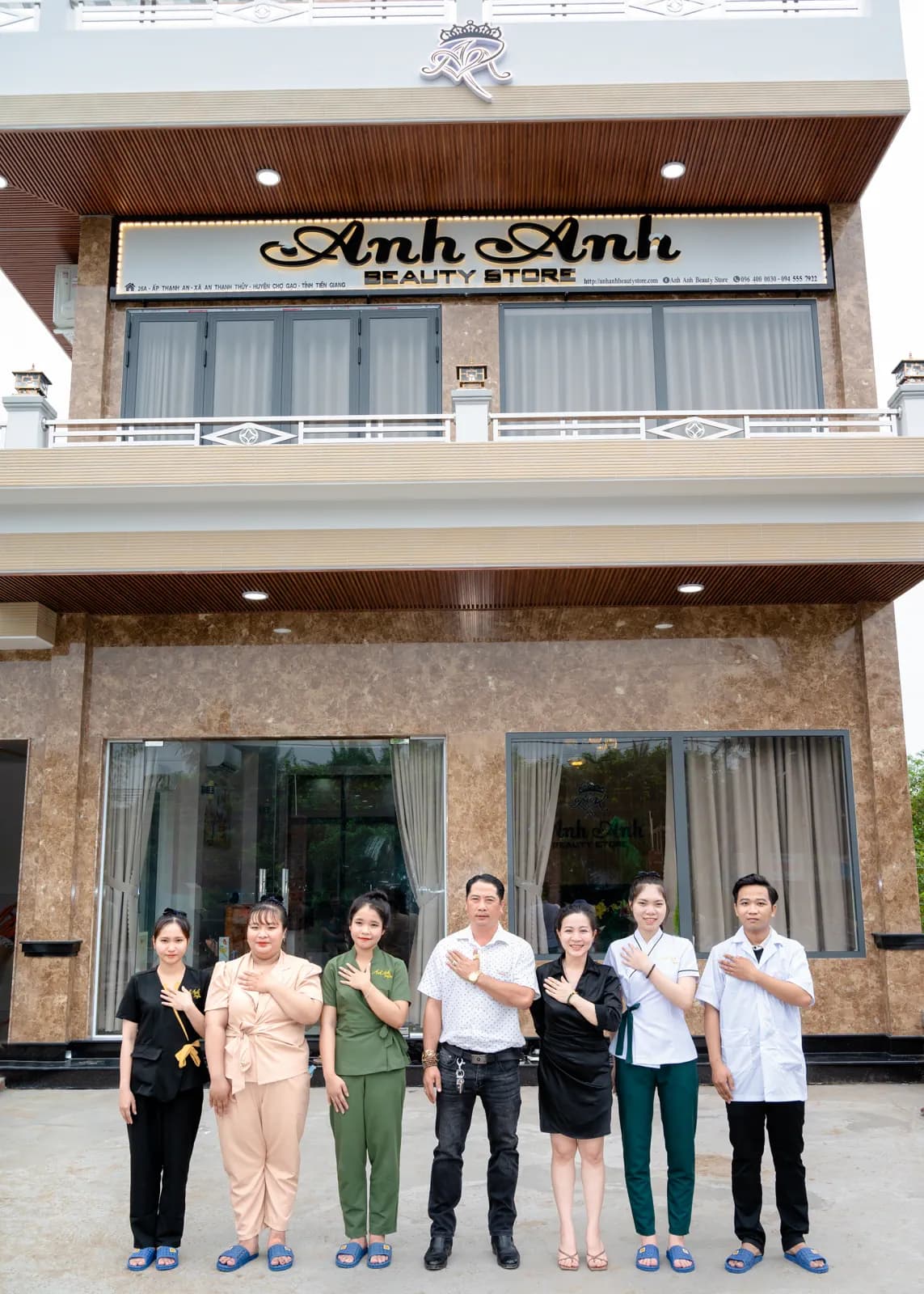 Mặt tiền hai tầng và nhóm người đứng trước cửa