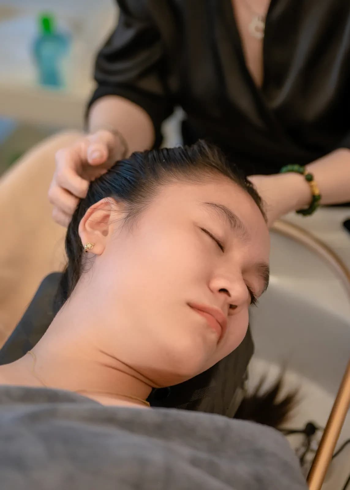Bàn tay vuốt mái tóc của người nằm cạnh bồn gội