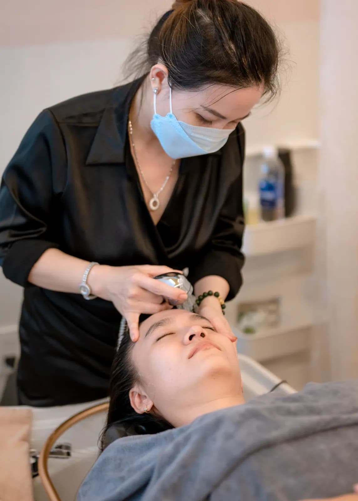 Người đeo khẩu trang cúi xuống bên người nằm trên giường