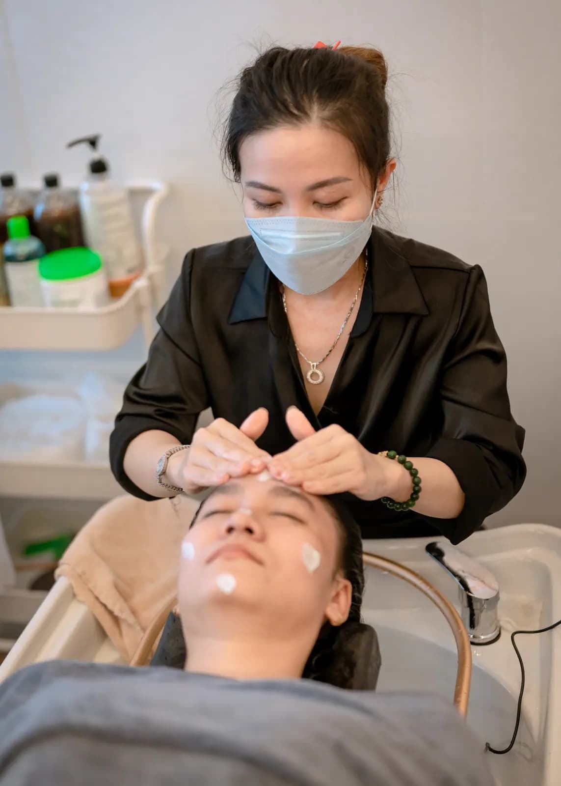 Người đeo khẩu trang thao tác gần trán người nằm