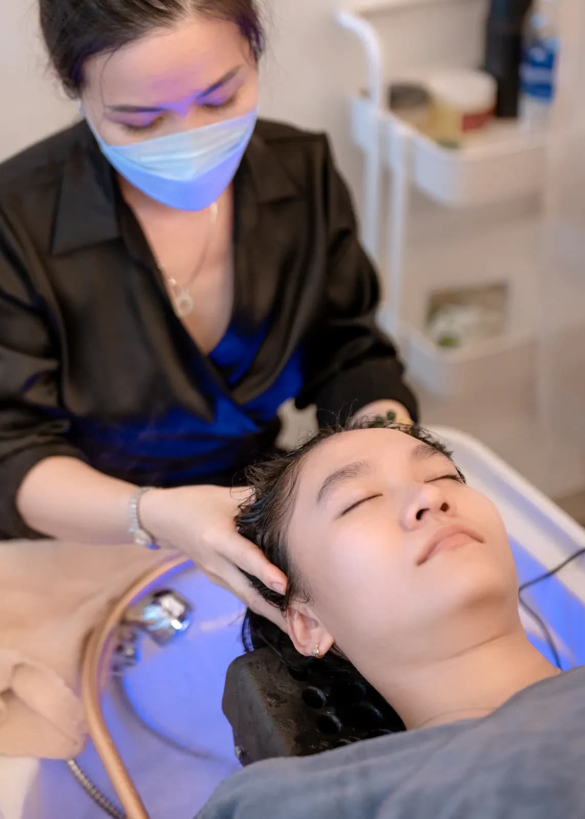 Một người đang nằm cạnh bồn gội màu sáng