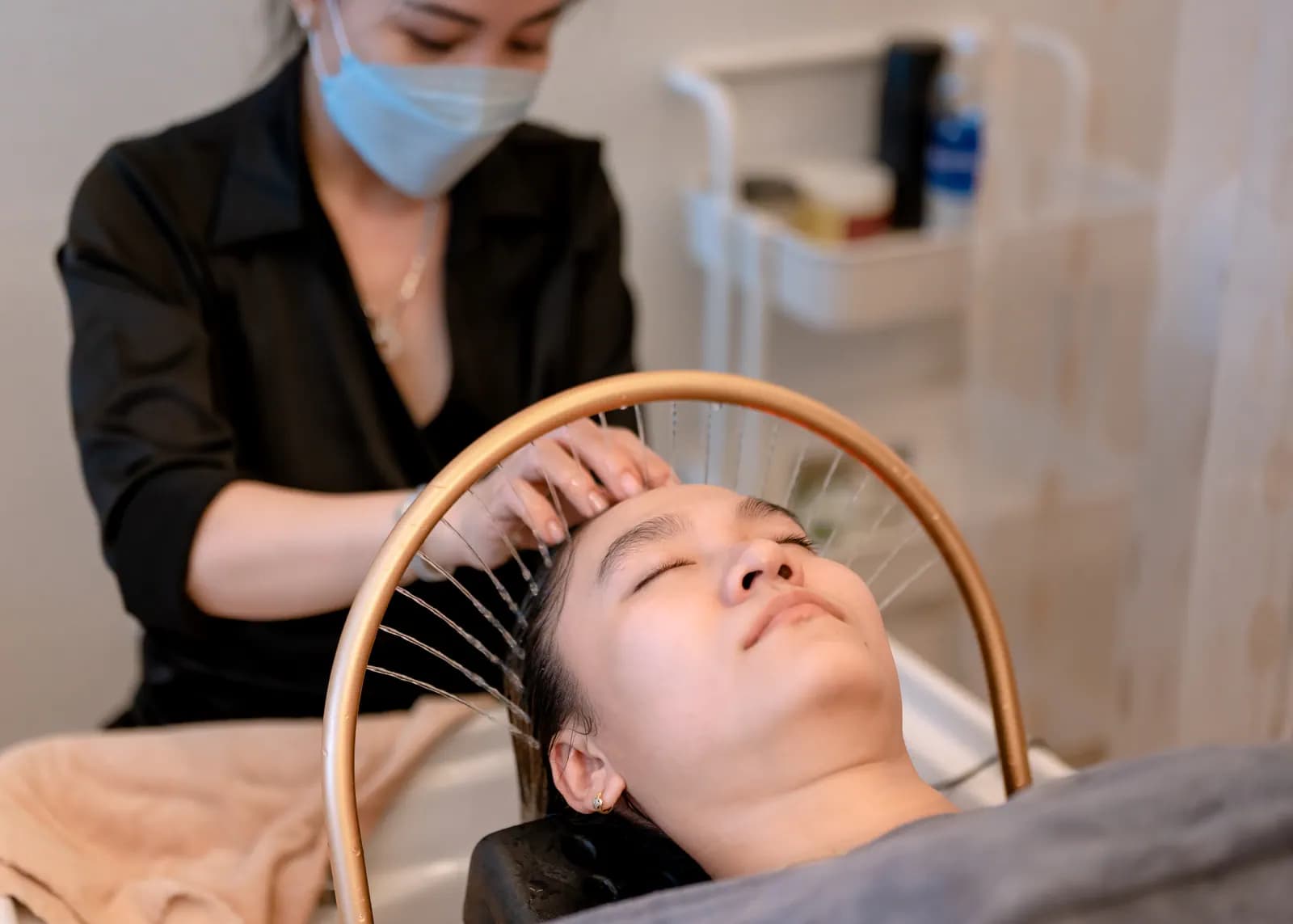 Người đeo khẩu trang cầm vòng nước phía trên đầu người nằm