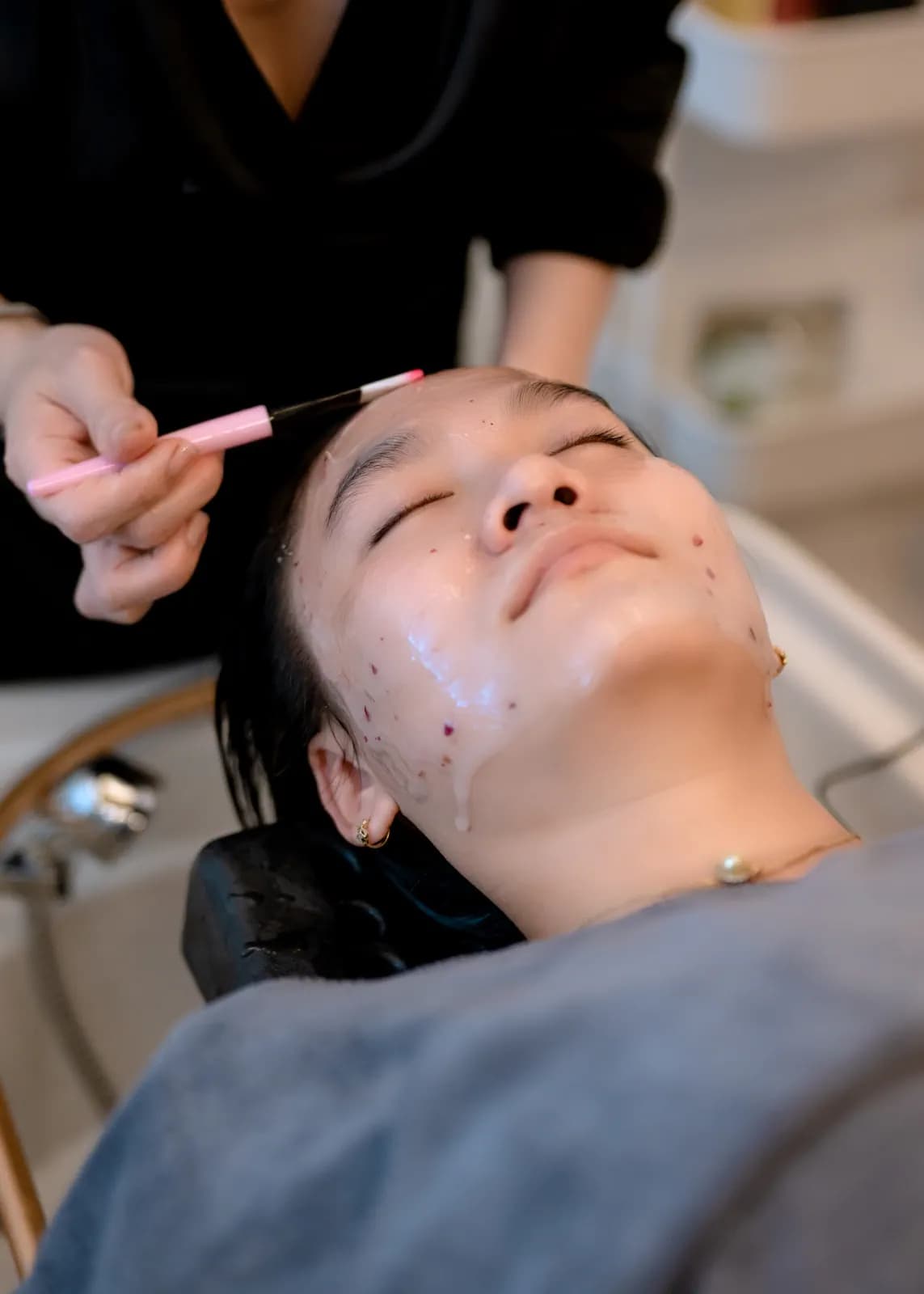 Một chiếc cọ được đưa tới gương mặt người nằm