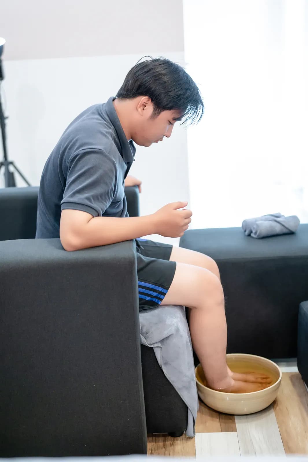 Một người ngồi làm việc cạnh giường trong căn phòng sáng