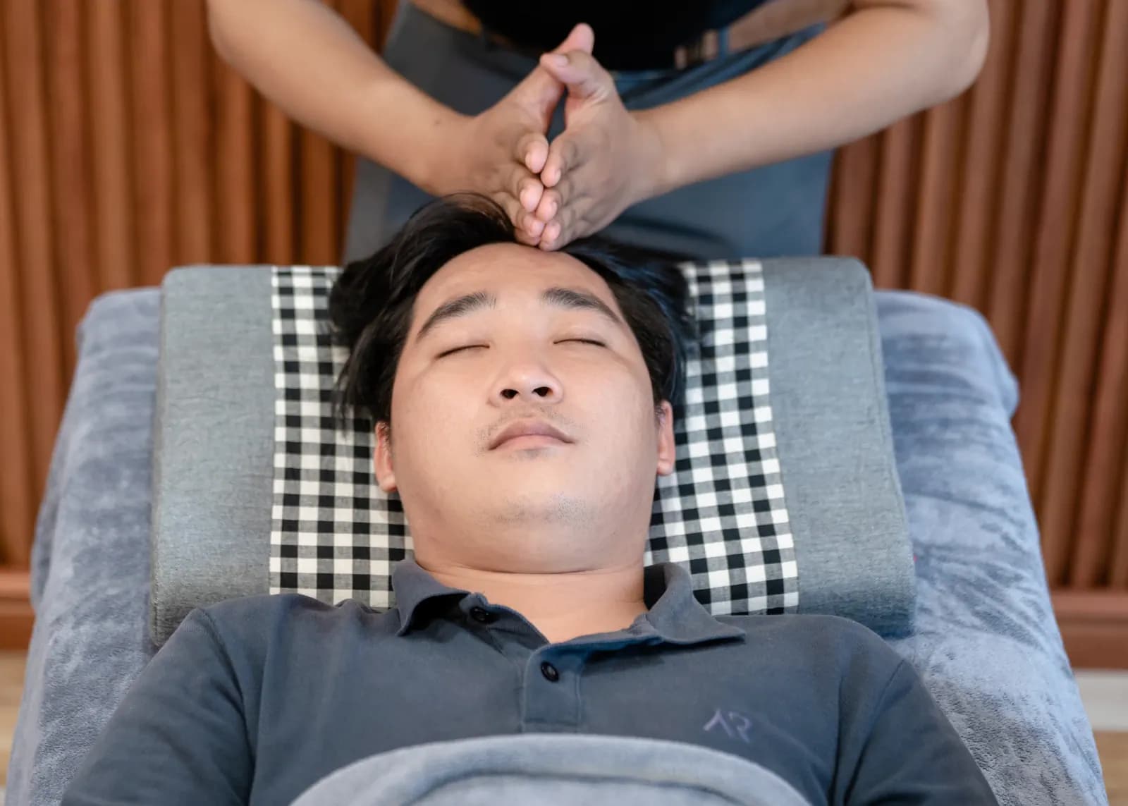 Hai bàn tay đặt trên đầu người đang nằm ngửa