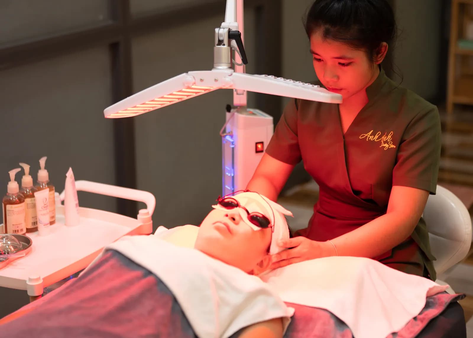Góc rộng một người đứng cạnh giường dưới ánh đèn đỏ
