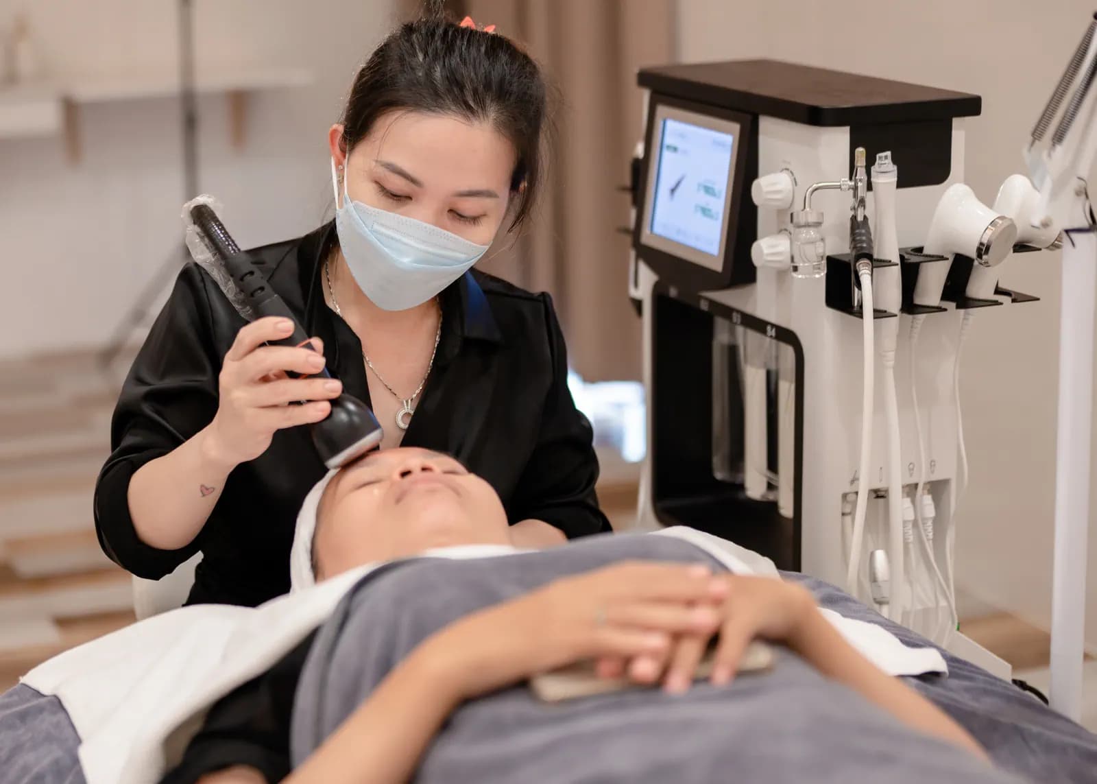 Một người cầm đầu thiết bị bên cạnh giường phủ khăn xám