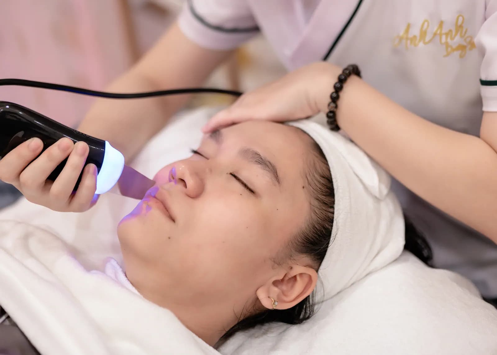 Đầu thiết bị phát ánh sáng tím gần má người nằm