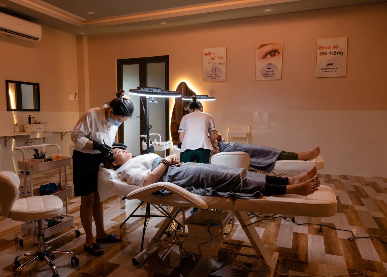 Căn phòng ánh đèn ấm với hai giường và người làm việc