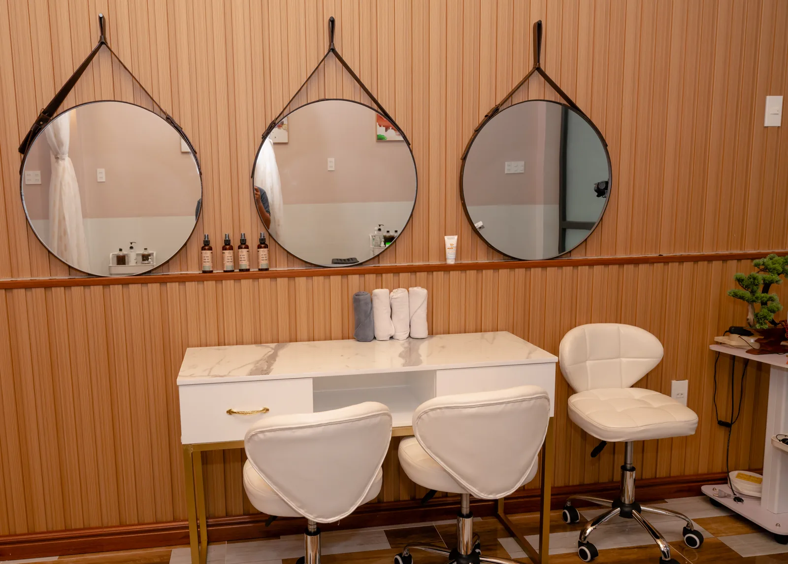 Three round mirrors above a long wood-clad counter